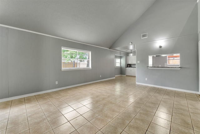 1865 El Mar Ln, Seabrook, TX 77586 - unfurnished living room featuring light tile patterned flooring, plenty of natural light, baseboards, and high vaulted ceiling