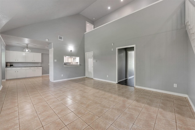 1865 El Mar Ln, Seabrook, TX 77586 - unfurnished living room with light tile patterned flooring, high vaulted ceiling, and baseboards