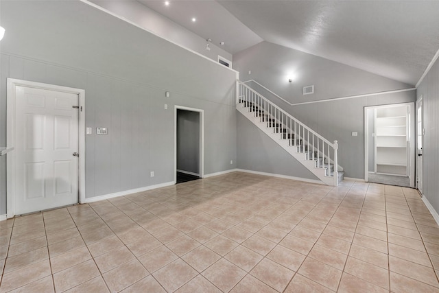 1865 El Mar Ln, Seabrook, TX 77586 - unfurnished living room featuring stairs, light tile patterned floors, lofted ceiling, and baseboards
