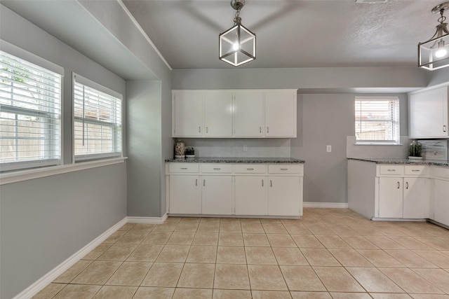 1865 El Mar Ln, Seabrook, TX 77586 - kitchen featuring white cabinets, light tile patterned floors, baseboards, dark stone countertops, and pendant lighting