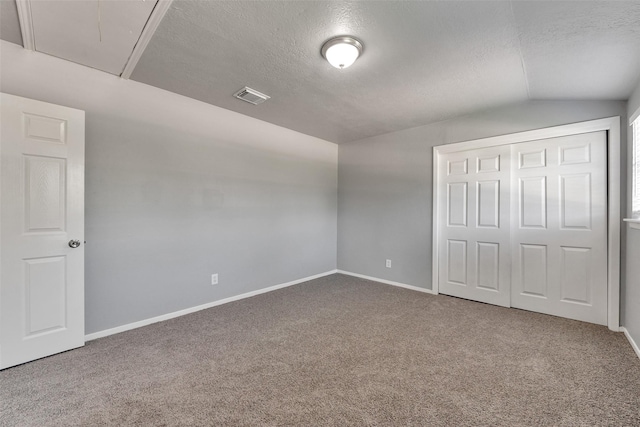 1865 El Mar Ln, Seabrook, TX 77586 - unfurnished bedroom featuring lofted ceiling, a textured ceiling, attic access, carpet floors, and baseboards