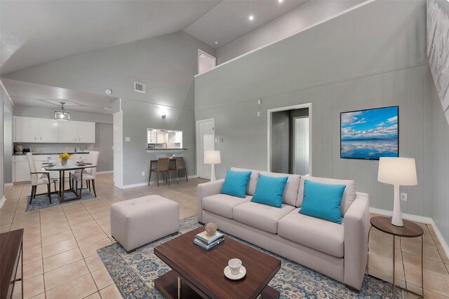 1865 El Mar Ln, Seabrook, TX 77586 - living room featuring light tile patterned flooring, high vaulted ceiling, and baseboards