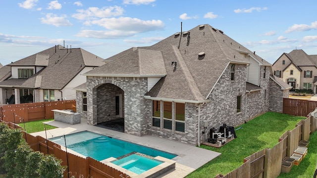back of property with brick siding, a yard, a patio, a fenced backyard, and a shingled roof