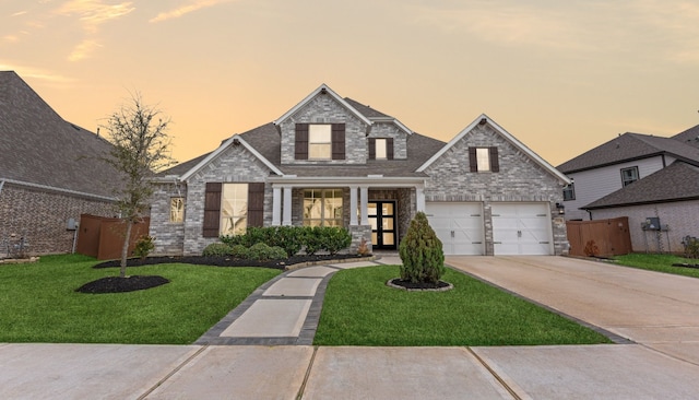 view of front facade with brick siding, a garage, stone siding, concrete driveway, and a front yard