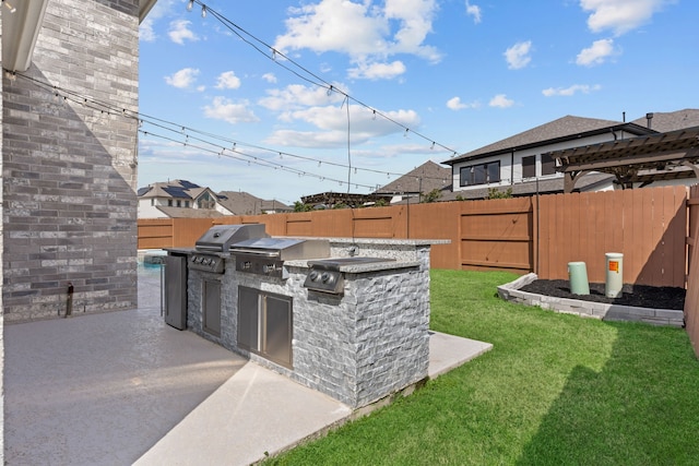 view of patio featuring a fenced backyard, area for grilling, and an outdoor kitchen
