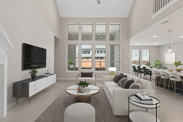 living area featuring a ceiling fan, baseboards, high vaulted ceiling, and light tile patterned flooring