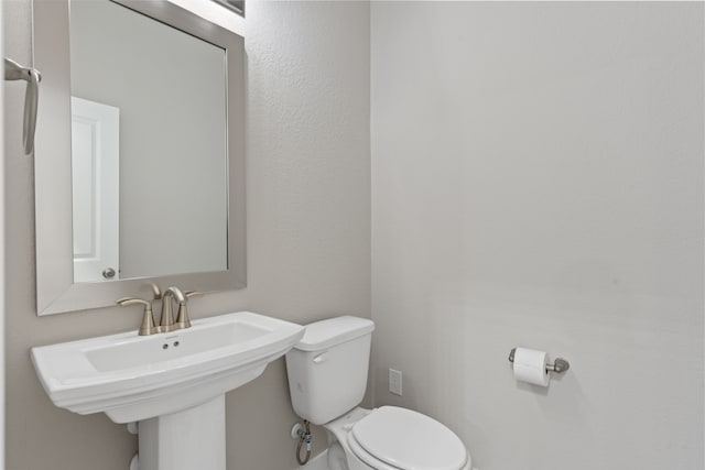 half bathroom with toilet and a sink