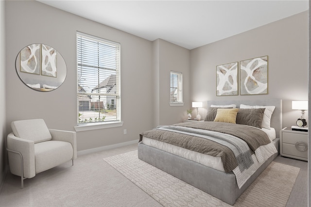 bedroom with baseboards and light colored carpet