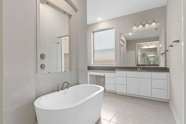 bathroom with a tile shower, tile patterned flooring, vanity, and a freestanding bath