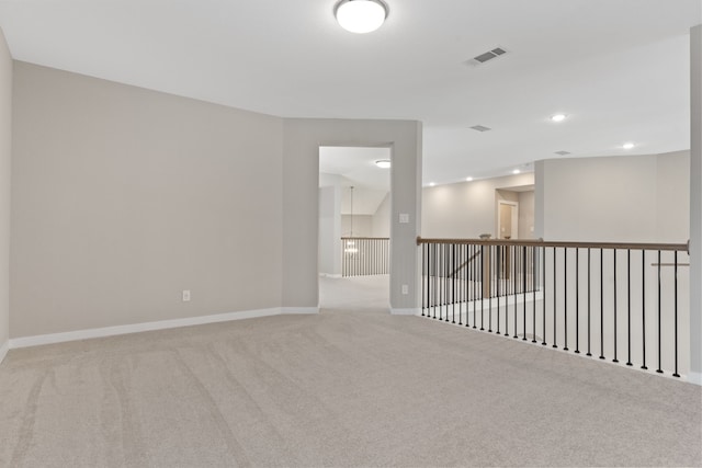 carpeted spare room featuring baseboards, visible vents, and recessed lighting