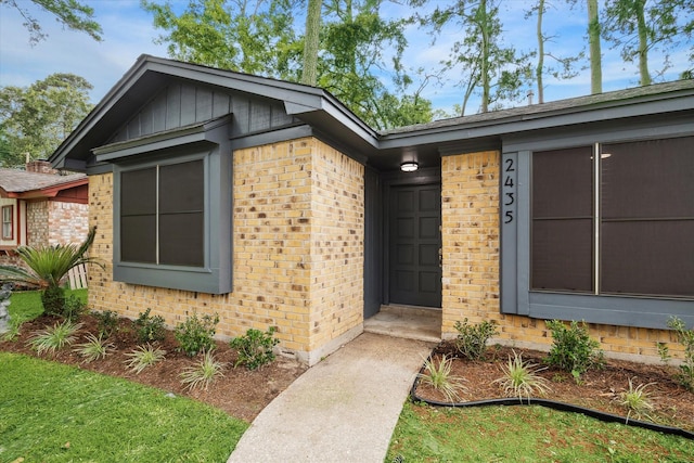 property entrance with brick siding and board and batten siding