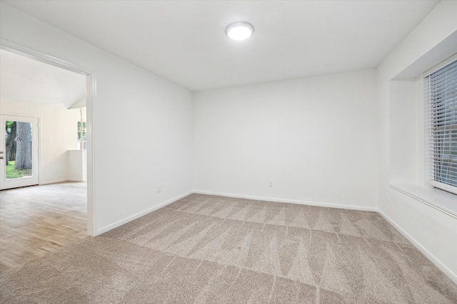 carpeted empty room featuring baseboards