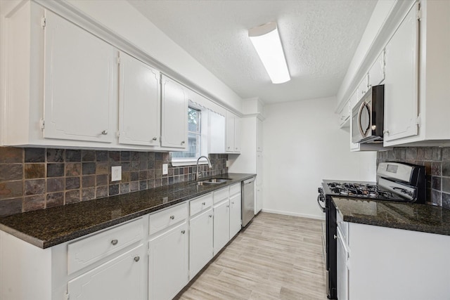 kitchen featuring a sink, a textured ceiling, white cabinets, and appliances with stainless steel finishes