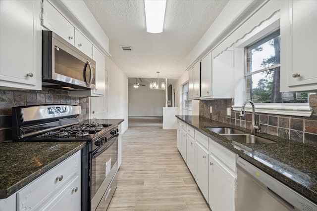 kitchen with white cabinetry, stainless steel appliances, visible vents, and a sink