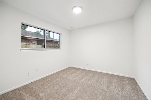 carpeted spare room featuring baseboards