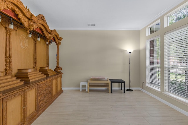 corridor featuring crown molding, baseboards, and visible vents