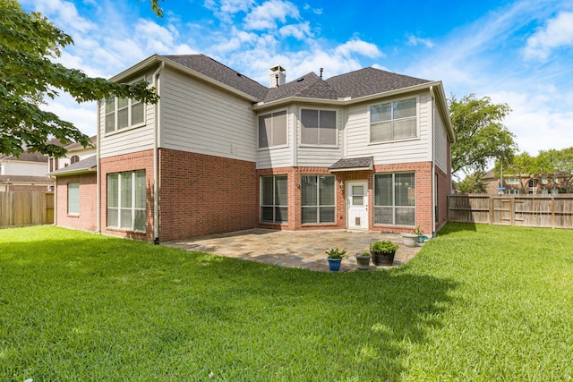 rear view of property featuring a patio area, brick siding, and a lawn