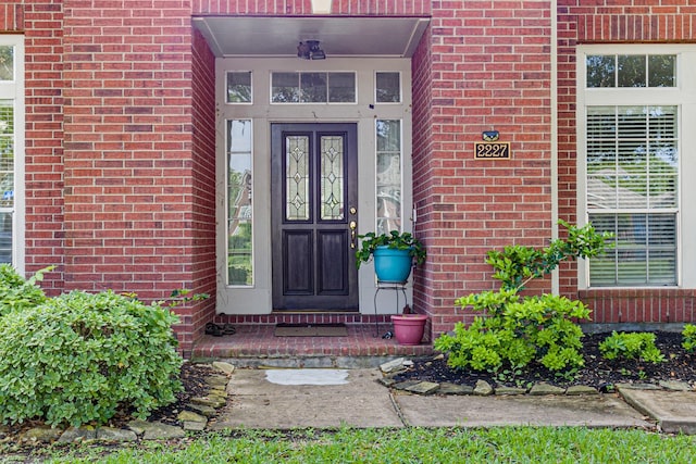 view of exterior entry featuring brick siding
