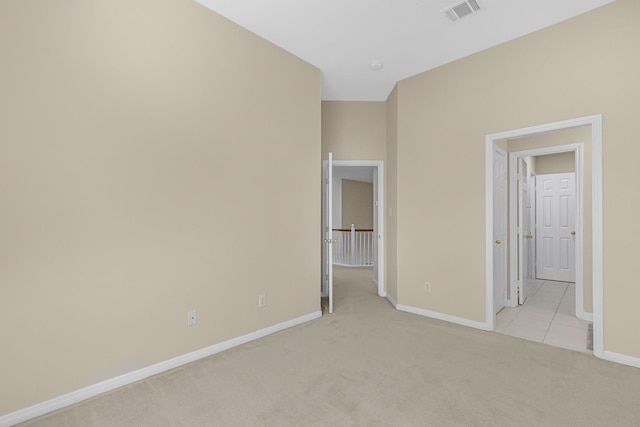unfurnished bedroom with visible vents, baseboards, and light carpet