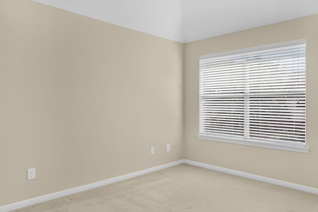 unfurnished room featuring baseboards, plenty of natural light, and light colored carpet