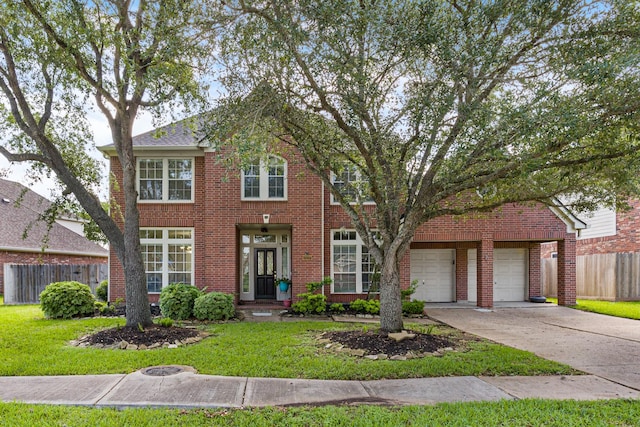 colonial-style house with a garage, driveway, fence, and a front yard