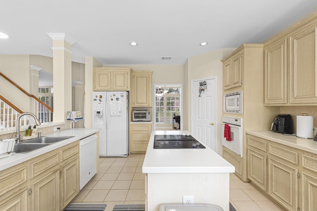 kitchen with a sink, white appliances, light countertops, a center island, and light tile patterned floors