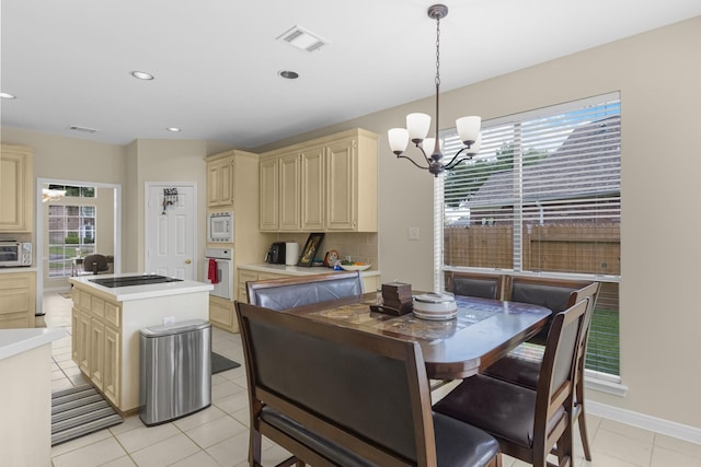 dining area with a wealth of natural light, visible vents, light tile patterned flooring, and a notable chandelier