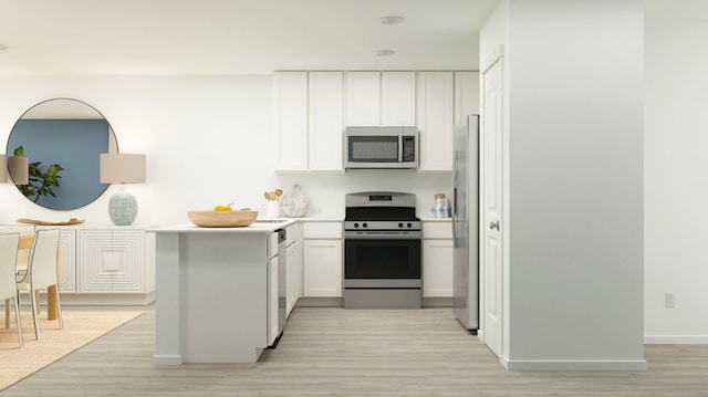 kitchen with white cabinets, light wood-style floors, and stainless steel appliances