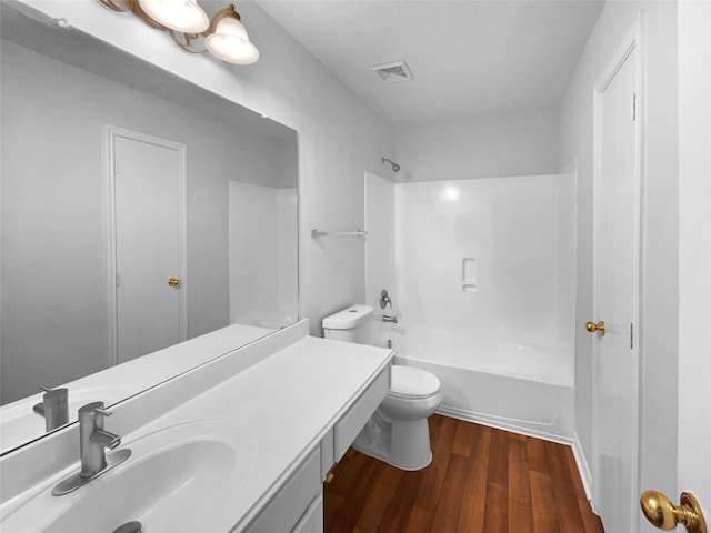 bathroom with toilet, wood finished floors, washtub / shower combination, visible vents, and vanity