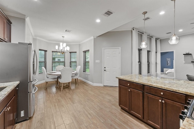 kitchen with freestanding refrigerator, ornamental molding, visible vents, an inviting chandelier, and baseboards