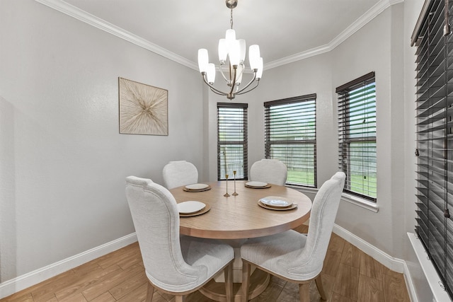 dining area with crown molding, light wood-type flooring, a chandelier, and baseboards