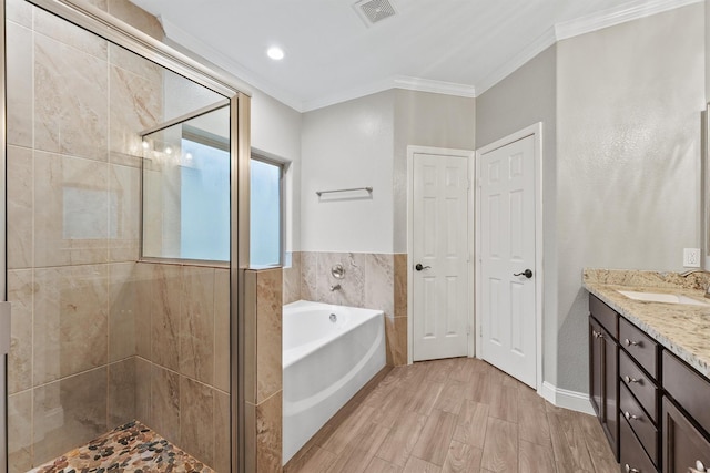 full bathroom featuring vanity, visible vents, crown molding, a shower stall, and a garden tub
