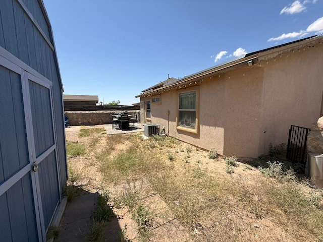view of yard with central air condition unit and a patio
