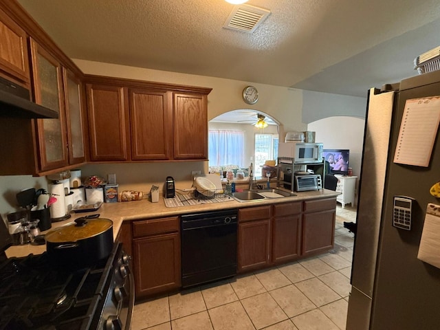 kitchen with light countertops, a sink, freestanding refrigerator, visible vents, and dishwasher