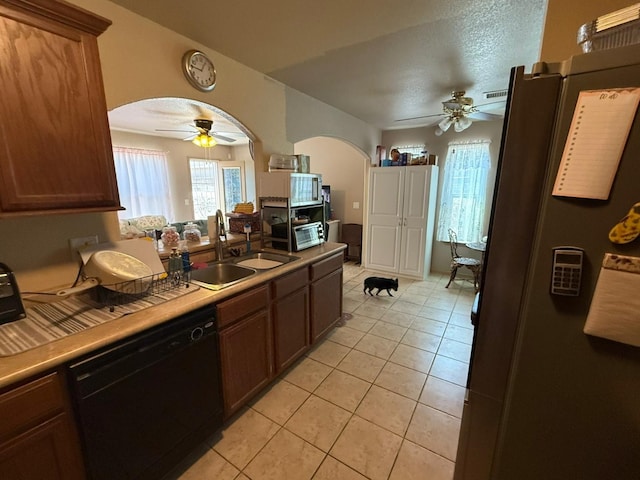 kitchen featuring ceiling fan, dishwasher, arched walkways, and a sink