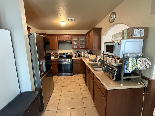 14220 English Point Ave, El Paso, TX 79938 - kitchen with refrigerator with ice dispenser, stainless steel gas range, light countertops, and under cabinet range hood
