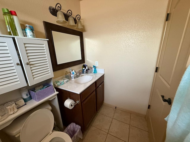 bathroom featuring toilet, baseboards, tile patterned flooring, and vanity