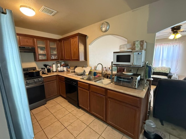 kitchen with a sink, stainless steel appliances, ventilation hood, visible vents, and light countertops