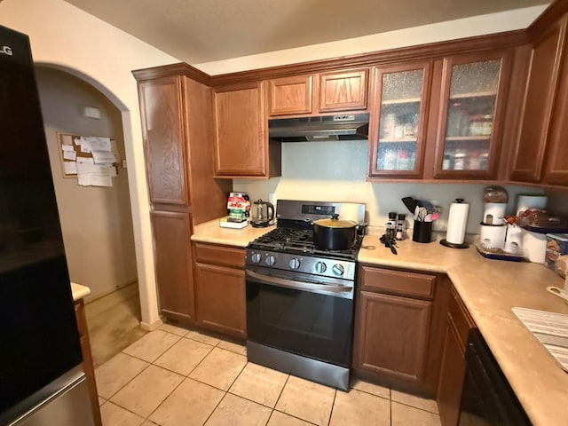 kitchen with light tile patterned floors, gas range, under cabinet range hood, light countertops, and dishwasher