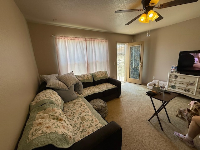 carpeted living room with a ceiling fan and a textured ceiling