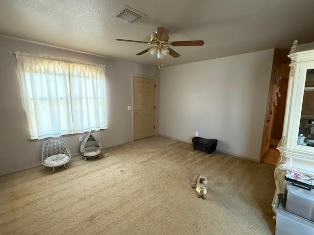 spare room with a ceiling fan, carpet flooring, visible vents, and baseboards