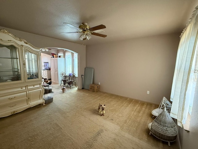 unfurnished bedroom with ceiling fan, arched walkways, and carpet floors