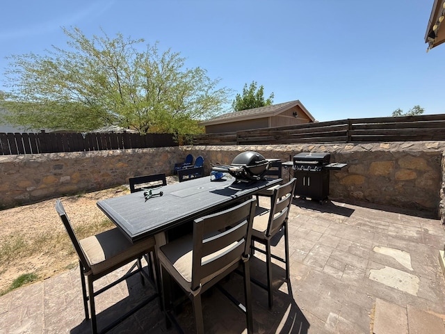view of patio featuring area for grilling, outdoor dining area, and a fenced backyard