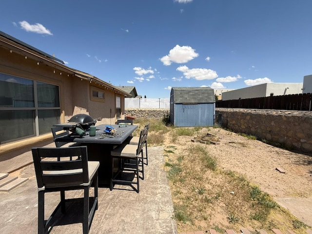 view of yard with a patio area, an outdoor structure, a fenced backyard, and a storage unit