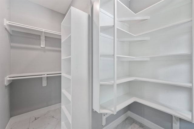 spacious closet featuring marble finish floor