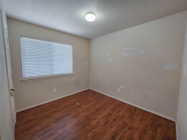 unfurnished room with wood finished floors and baseboards
