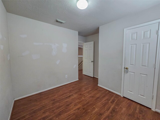 unfurnished bedroom with baseboards, visible vents, and wood finished floors