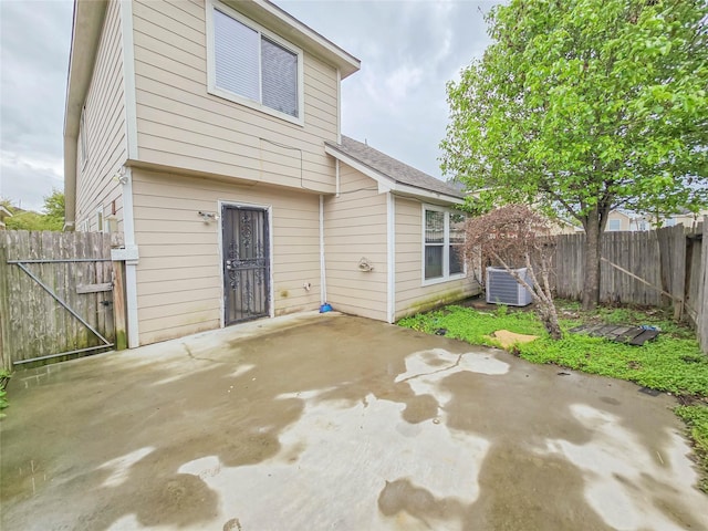 back of house featuring cooling unit, a patio, fence, and a gate