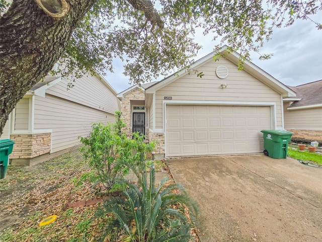 ranch-style home with stone siding, concrete driveway, and a garage