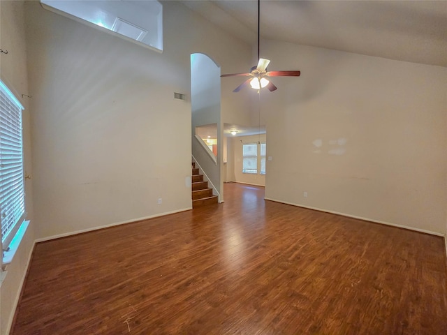 unfurnished living room featuring ceiling fan, stairs, high vaulted ceiling, and wood finished floors